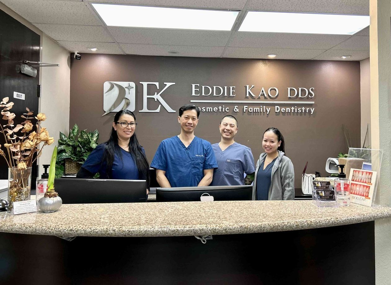 Reception area of Eddie Kao DDS, with staff smiling behind the front desk.
