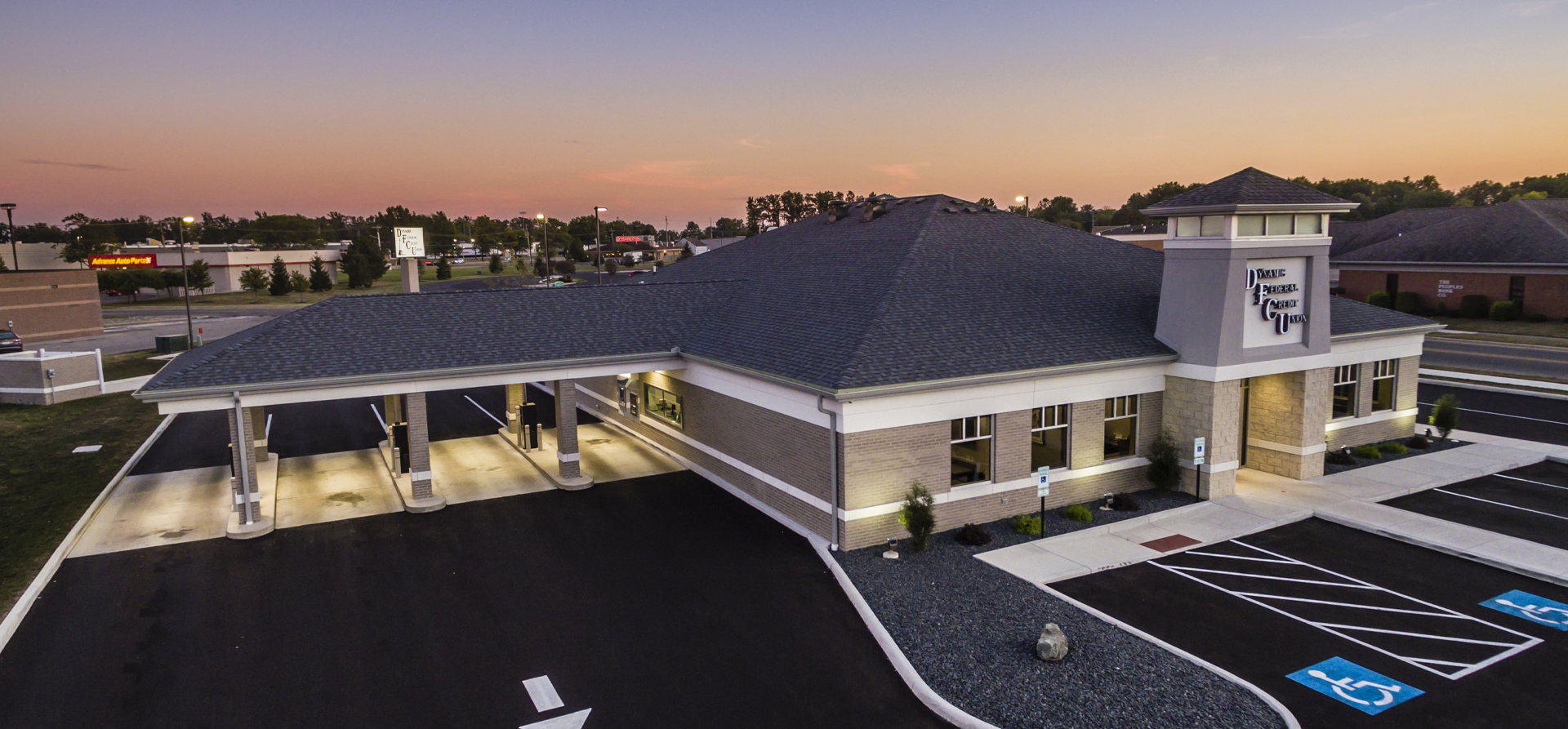Dayton, OH, Driveway Federal Credit Union building. Gray brick exterior, light blue sky with clouds.