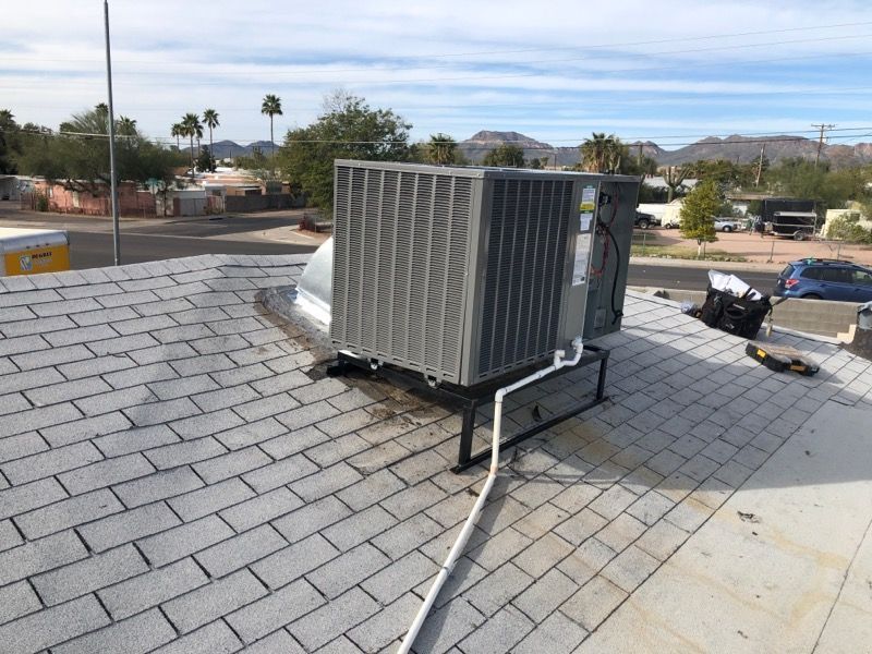 A large air conditioner is sitting on top of a roof.
