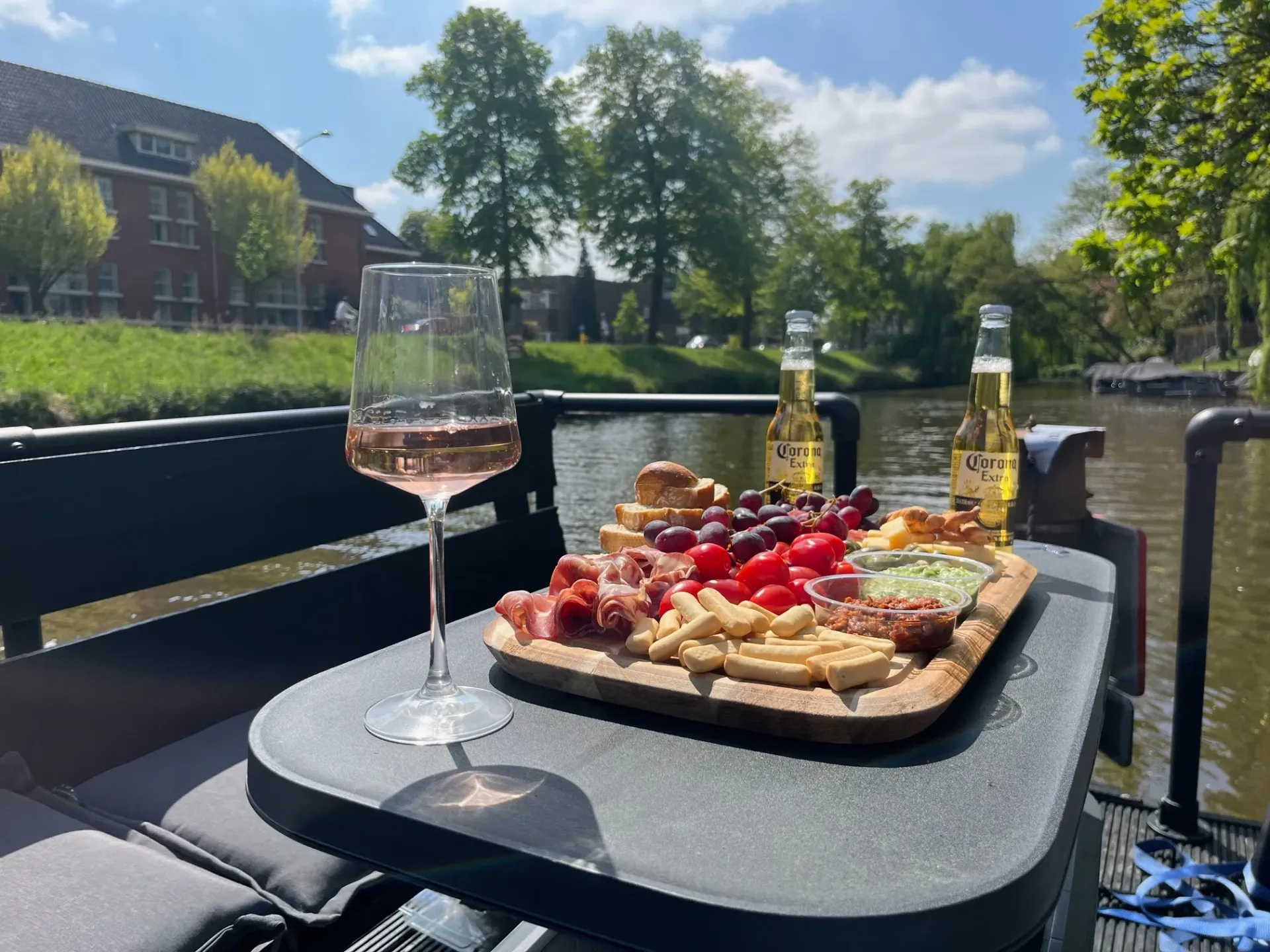 Een tafel met daarop een dienblad met eten en een glas wijn.
