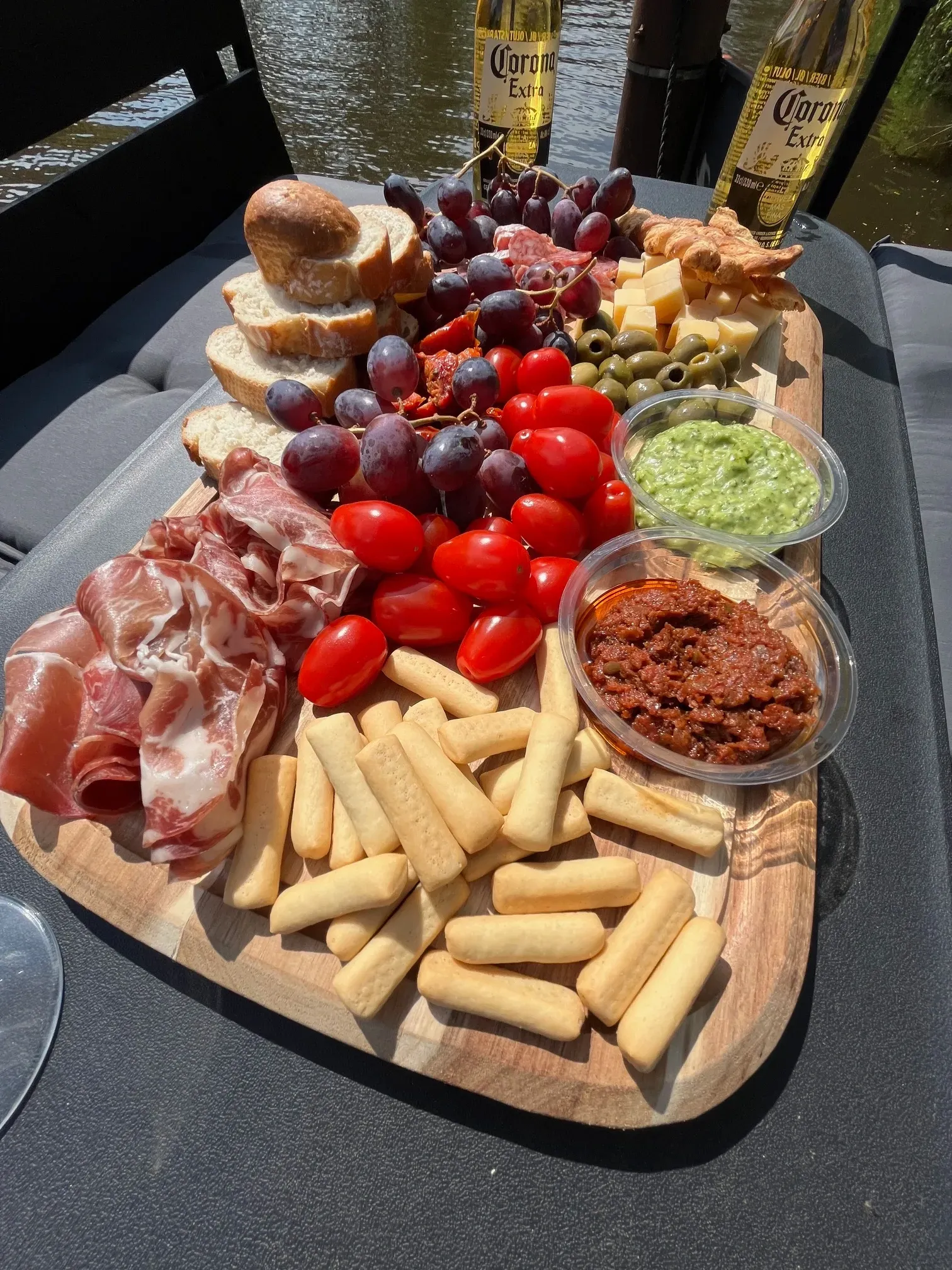 Een houten snijplank gevuld met eten en een fles corona bier.