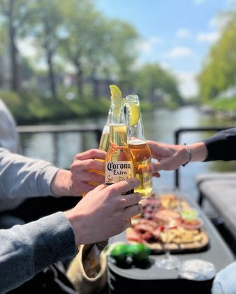 Een groep mensen toost met coronabier
