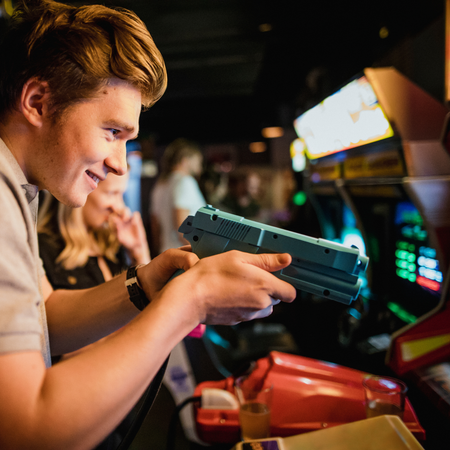 G&G Arcade Custom Cabinets | a man holding a light gun in arcade