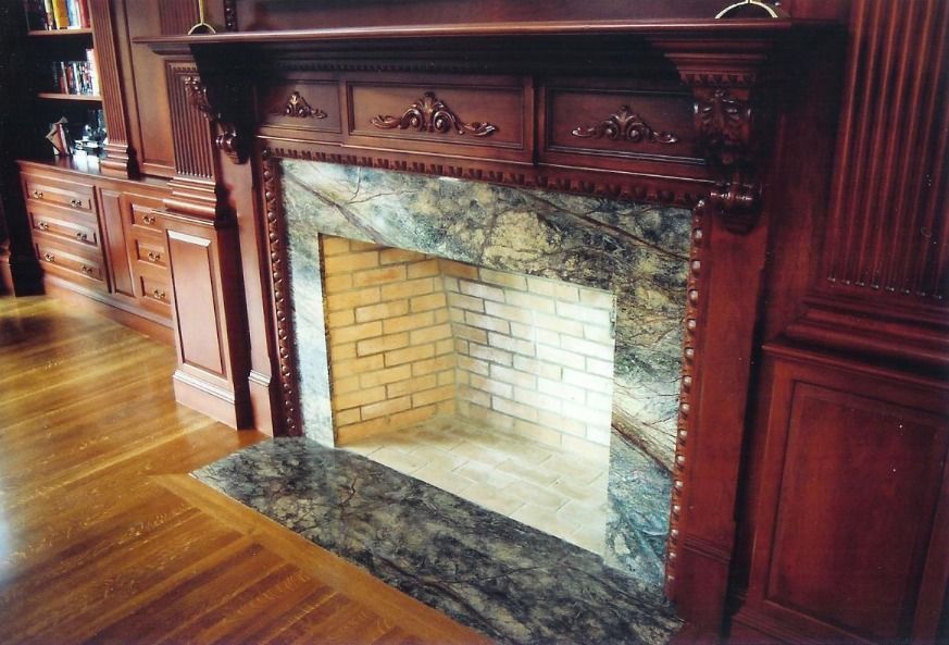 Fireplace with marble surround and brick interior; dark wood mantel and built-ins.
