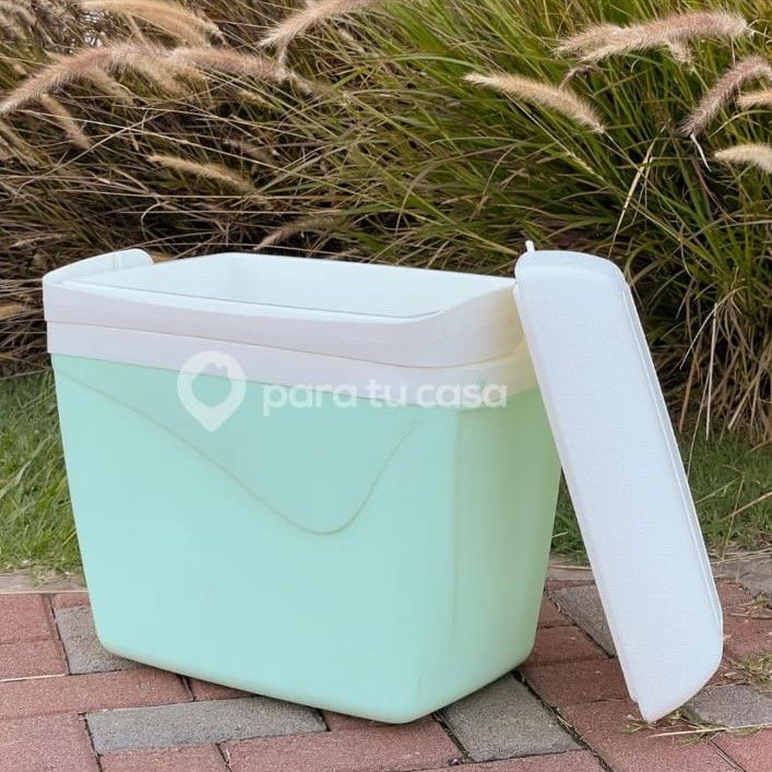 Contenedor de almacenamiento de plástico de color verde menta con tapa blanca en un entorno al aire libre.