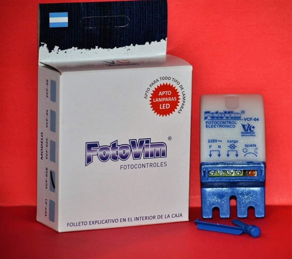 Caja y dispositivo de un fotocontrolador FotoVim, azul y blanco, para iluminación exterior. Fondo rojo.