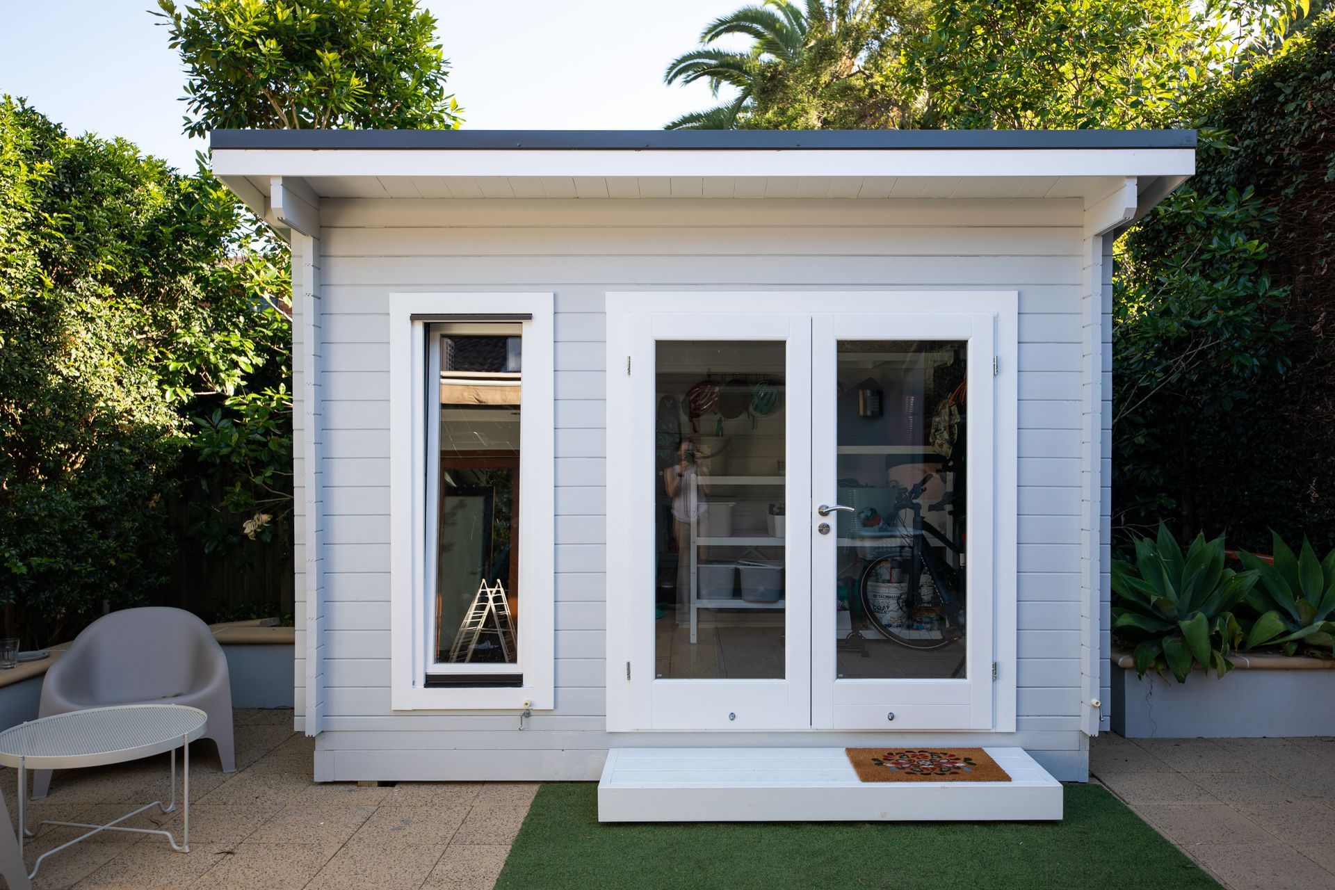 Une petite maison blanche avec beaucoup de fenêtres et de portes