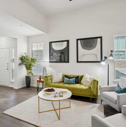 Living room with green sofa, two abstract paintings, and a coffee table.