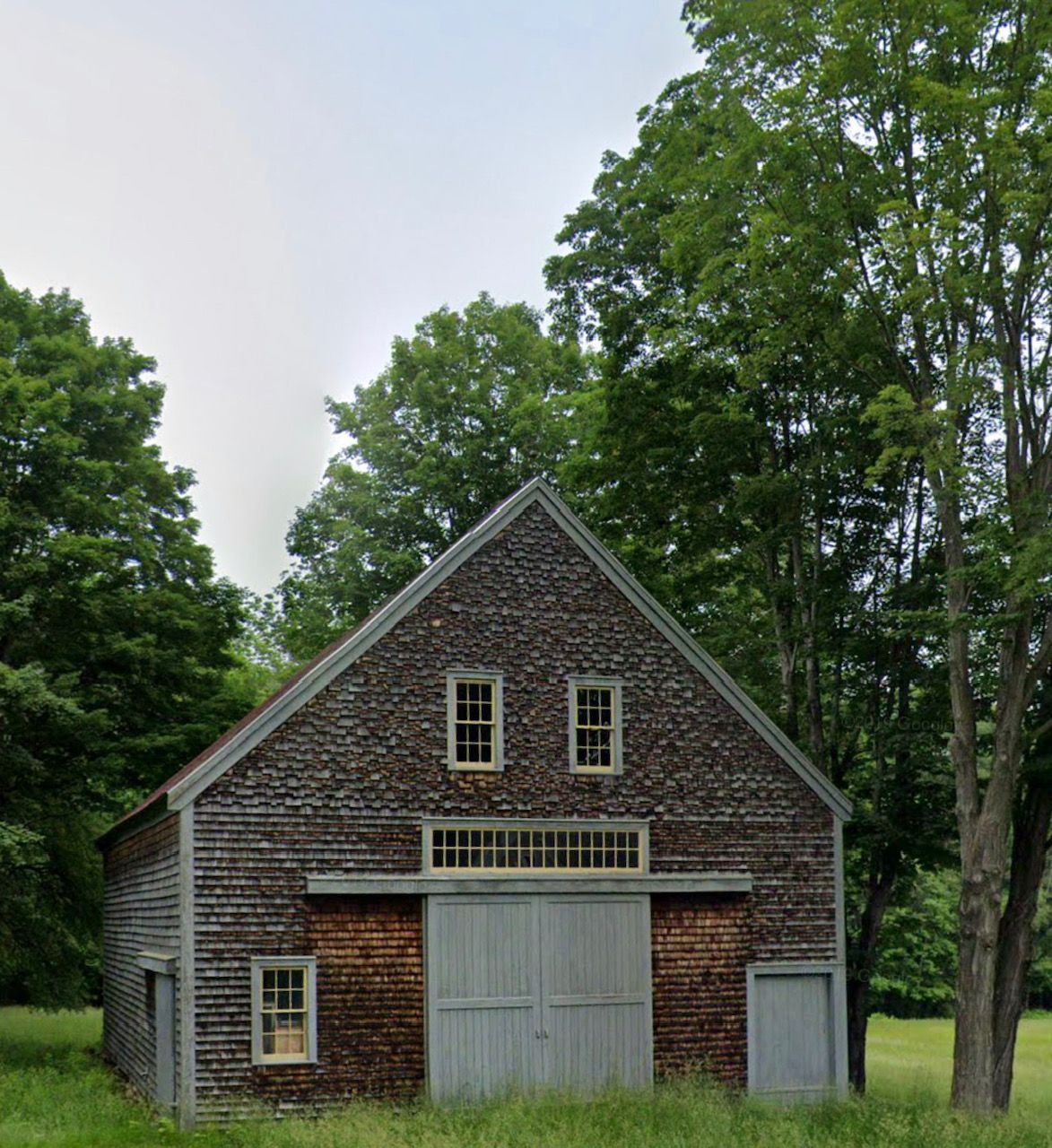 Waves crashing against rocky cliffs, ocean and blue sky in background.