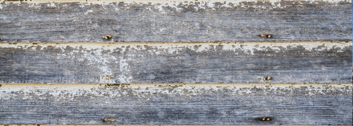 Weathered gray wood siding with peeling white paint.