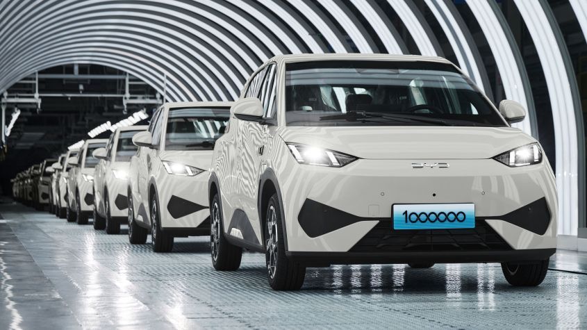 a row of white BYD EV cars on a production line