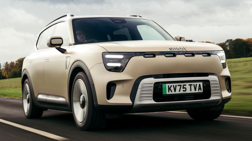 Beige Smart #5 on a road, front view, with a green license plate.