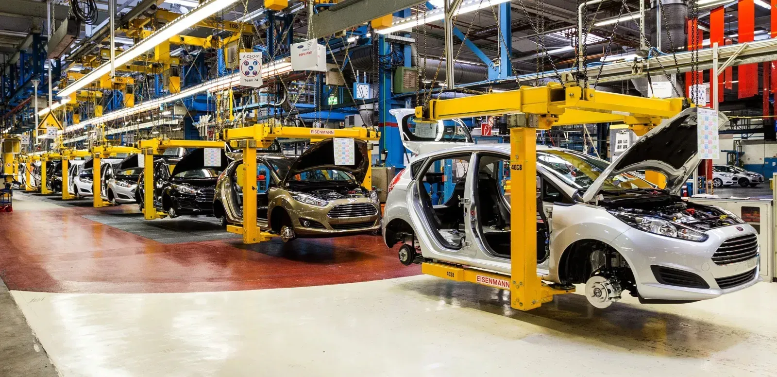 A row of cars are being built in a factory .