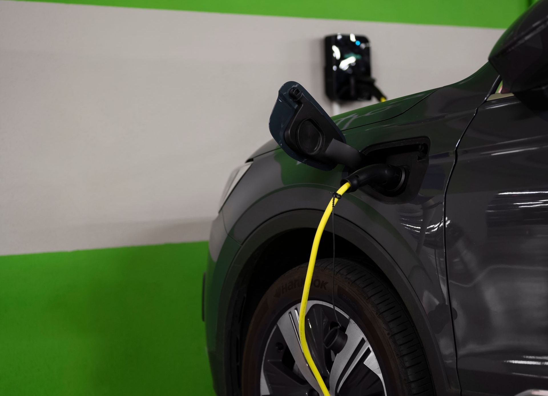 An electric car, being charged in a parking garage An electric car is being charged in a parking garage