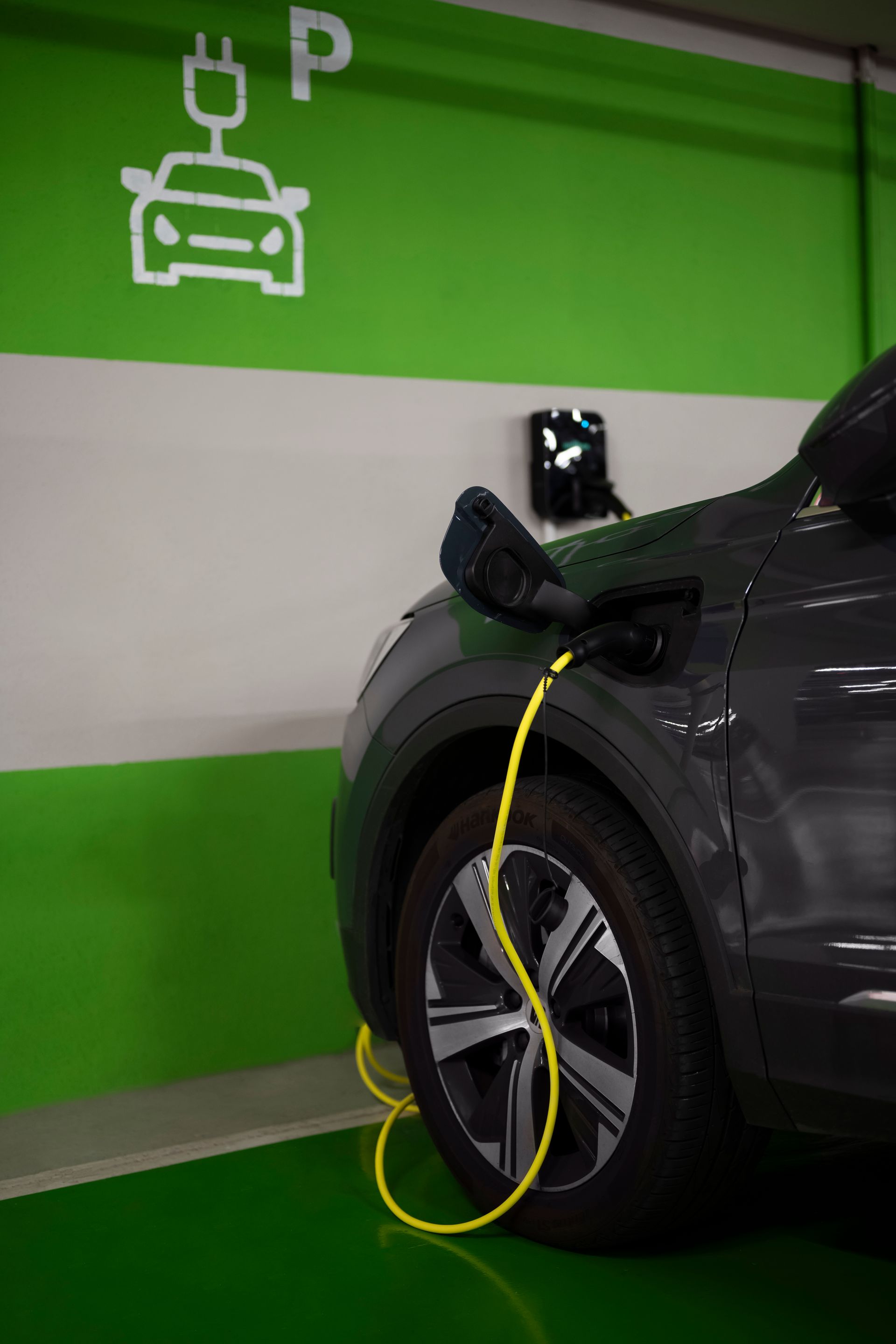 An electric car is being charged in a parking garage.