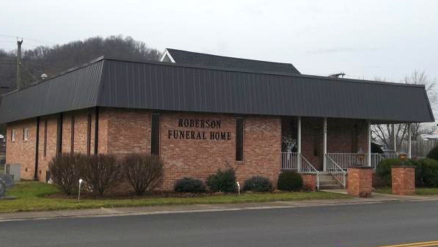 Robinson Funeral Home, brick building with dark roof, located in a town.