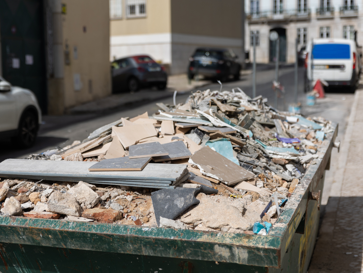 Dumpster overflowing with construction debris on a city street.