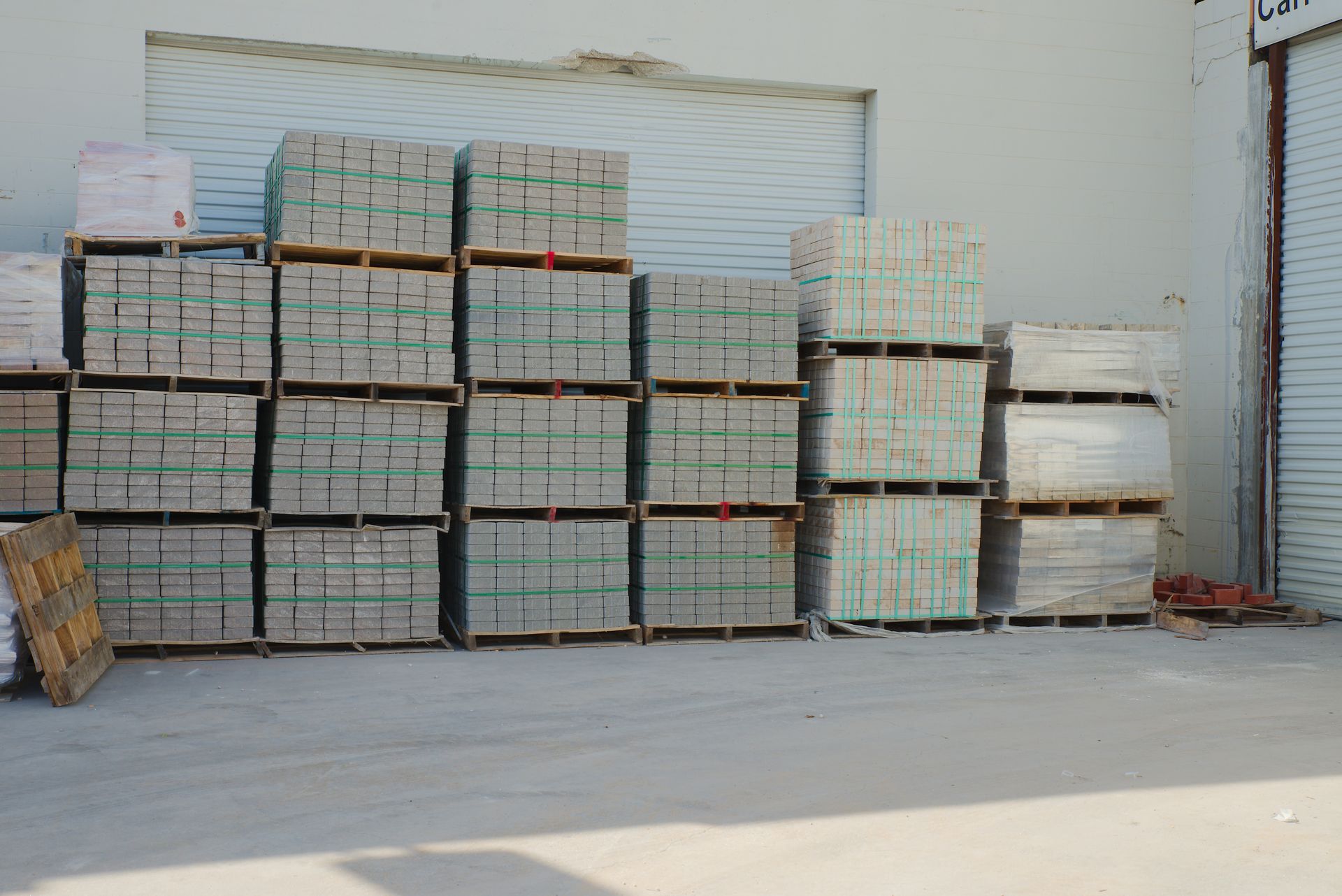 Neatly stacked pale bricks secured with green strapping.