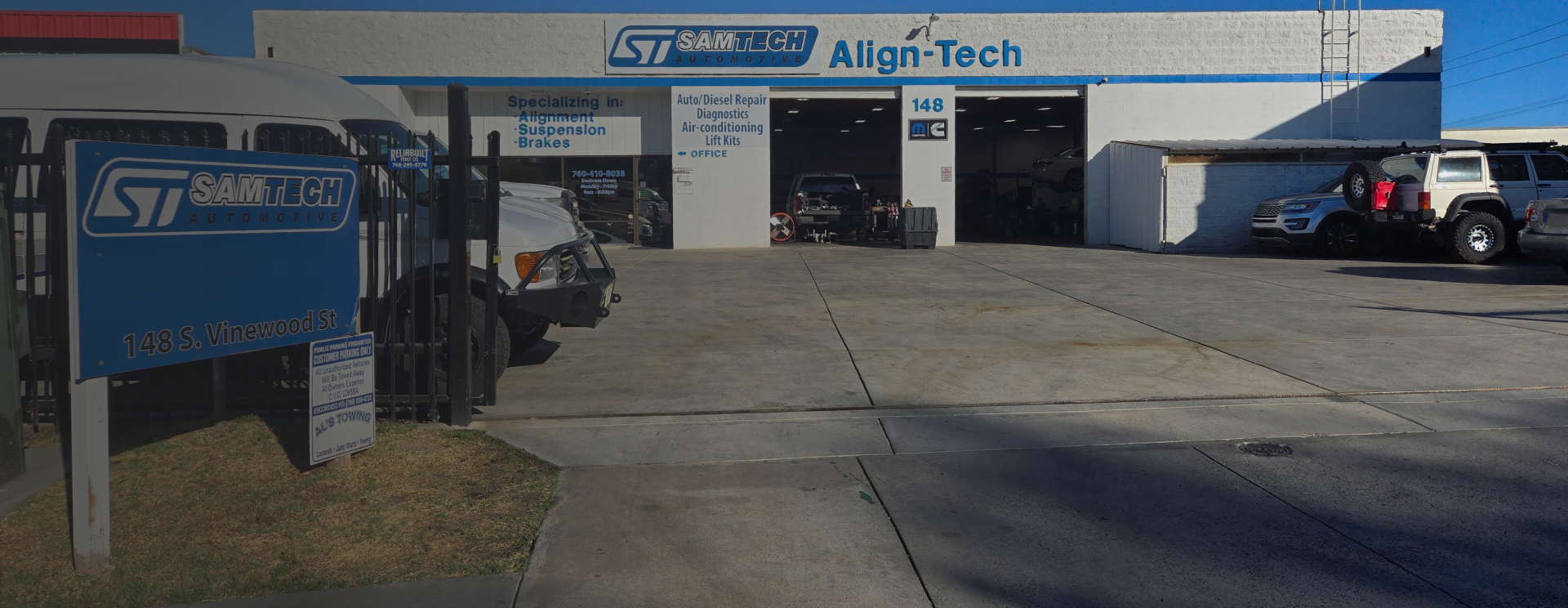 Two open garage doors, and vehicles parked outside | Samtech Automotive