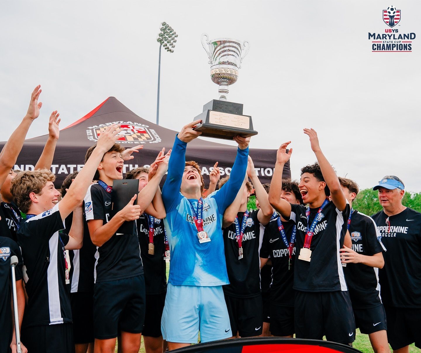 A group of soccer players are celebrating with a trophy