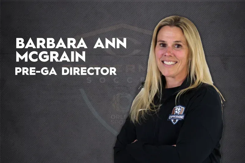 Barbara Ann McGrain, Pre-GA Director, standing in black jacket against a gray background.