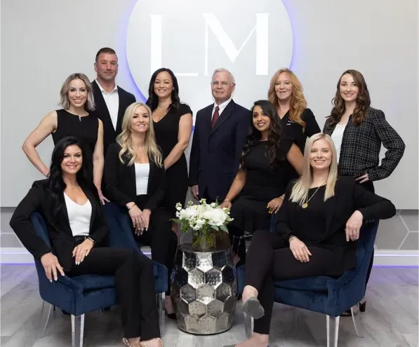 A group of people posing for a picture in front of a sign that says LifeMed