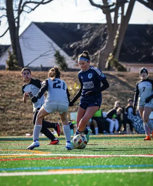 Soccer players in blue and white uniforms competing on a field during a match