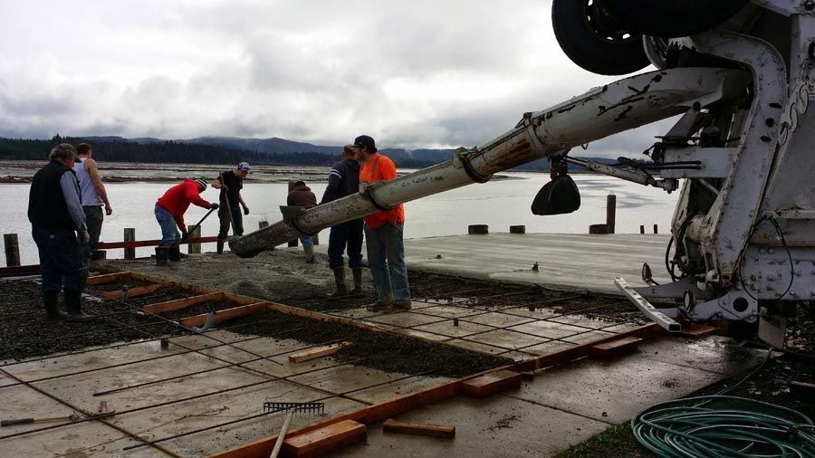 A group of people are working on a concrete dock.