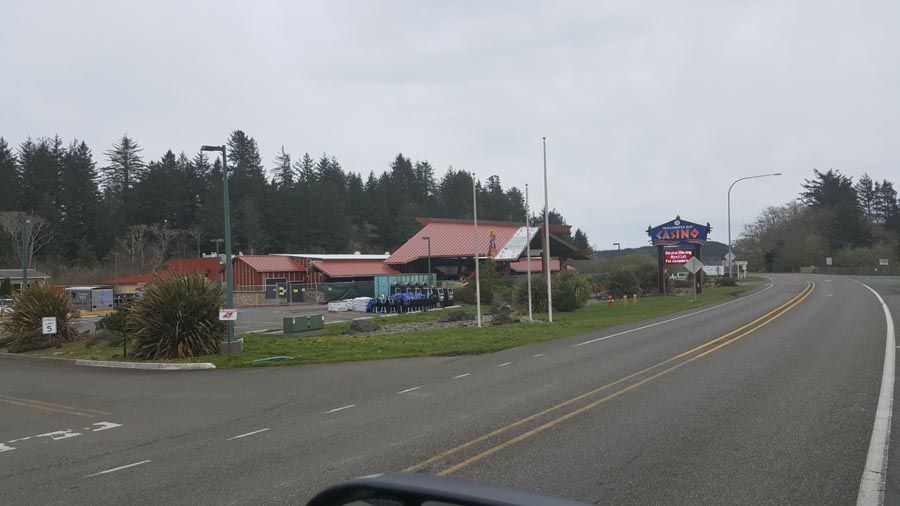 A car is driving down a road with a restaurant in the background.