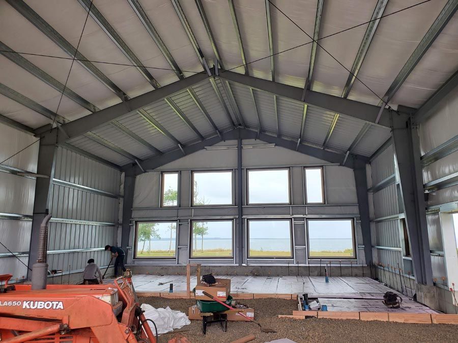 A large metal building with a lot of windows is being built.