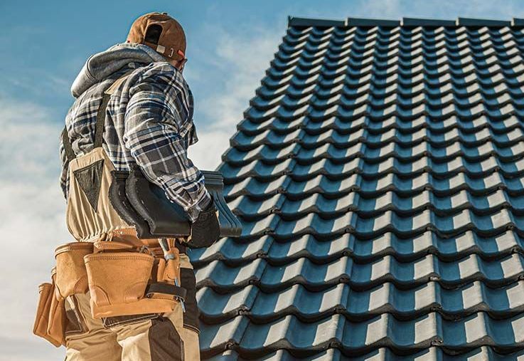 A group of men are working on the roof of a building.
