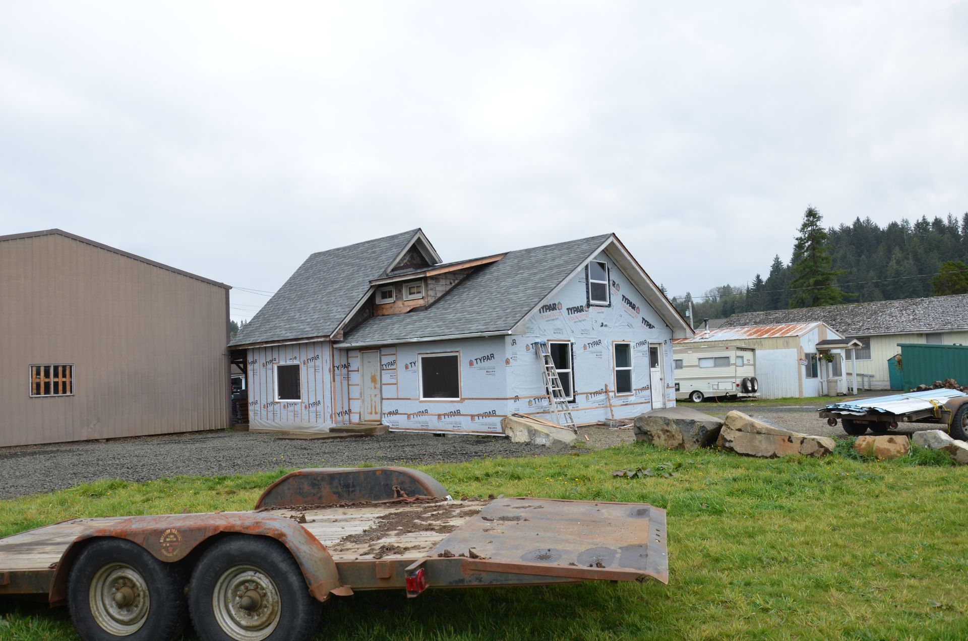 A trailer is parked in front of a house under construction.