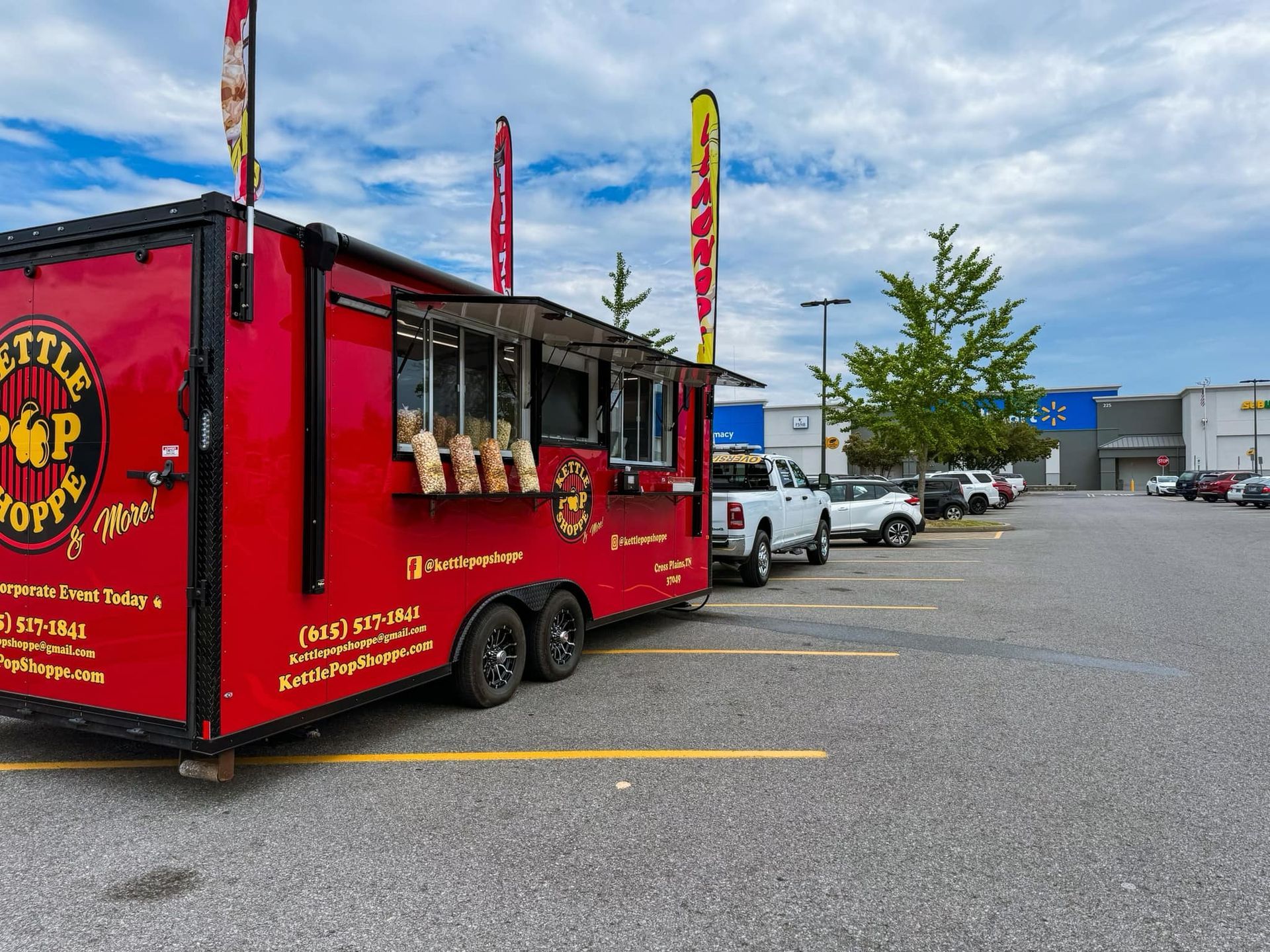 A red food truck is parked in a parking lot.