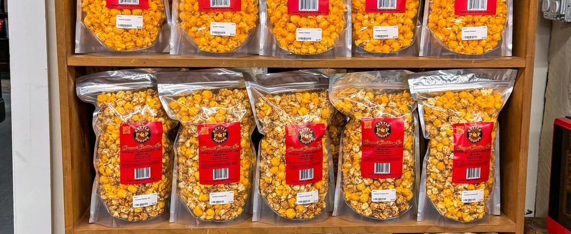 A shelf filled with bags of popcorn in a store.