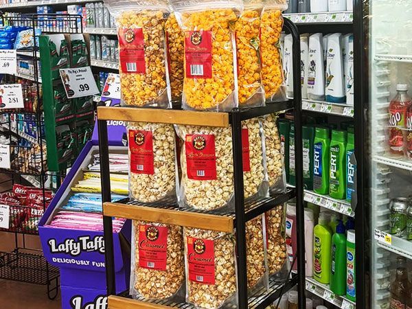 There are many bags of popcorn on display in a store.