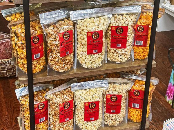 A shelf filled with bags of popcorn in different flavors.