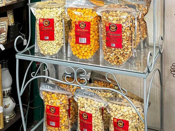 A shelf filled with bags of popcorn in different flavors.