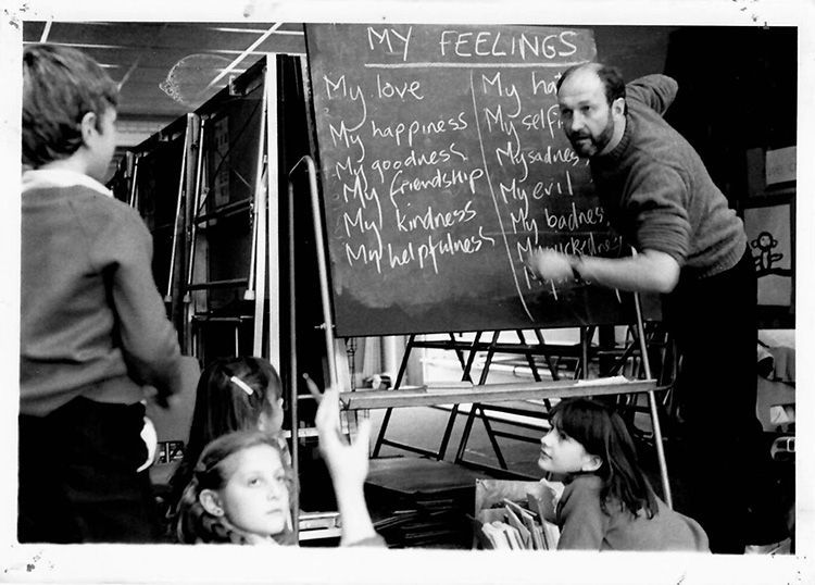 A man is writing on a blackboard about his feelings