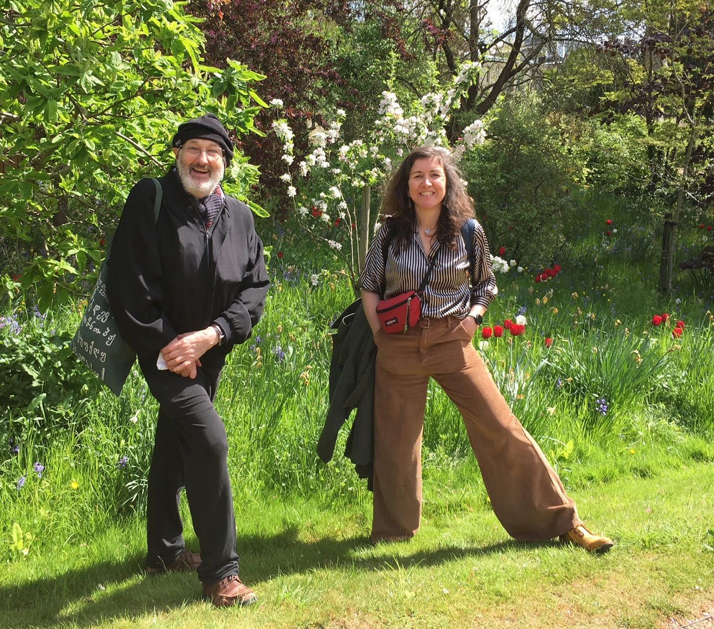 A man and a woman are standing in a grassy field.