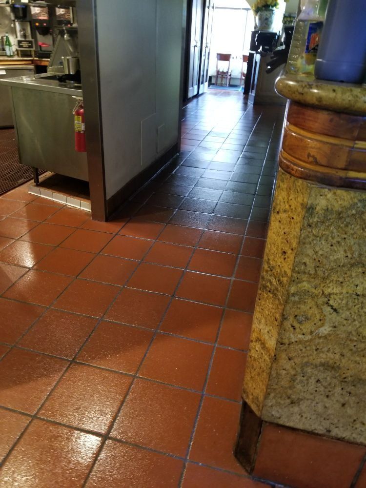 A restaurant with red tile floors and a granite counter top.