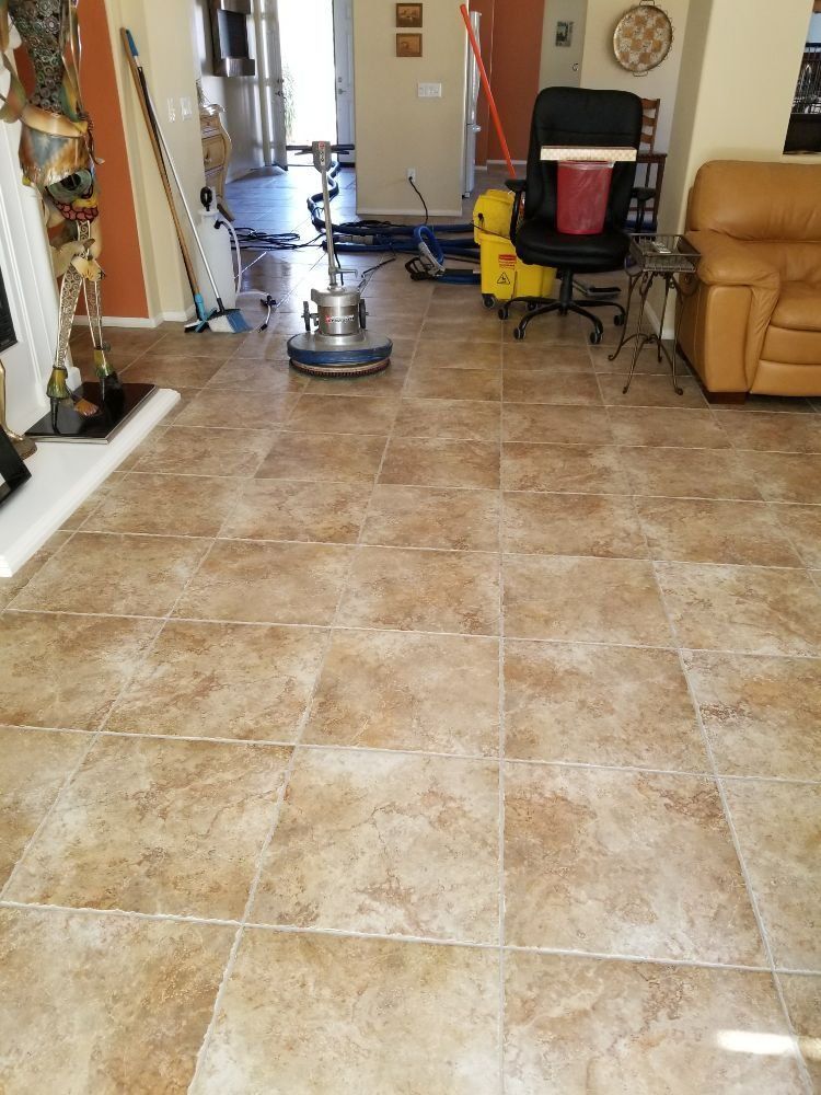A living room with tile floors and a vacuum cleaner.