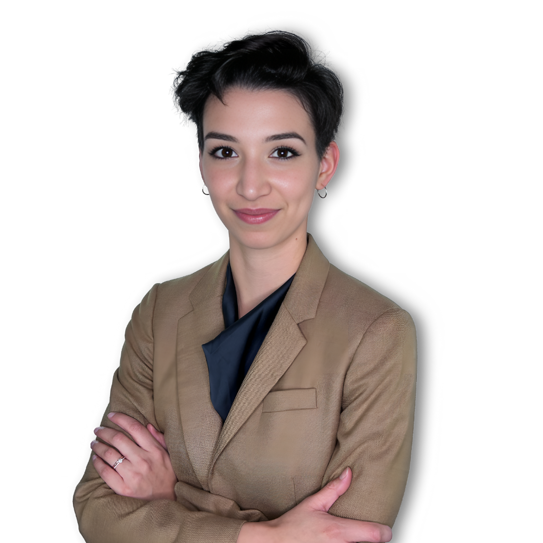 A woman in a tan jacket with her arms crossed