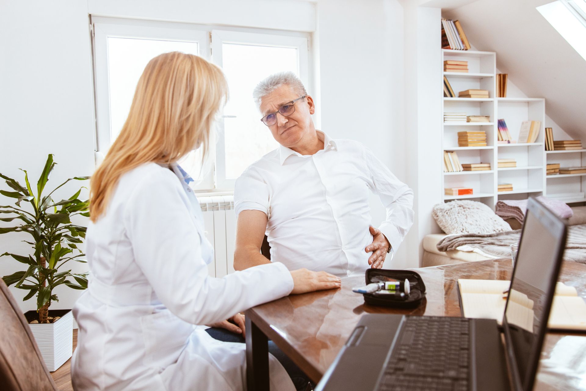 A Doctor and a Patient are Sitting at a Table with a Laptop — Orlando, FL — Central Florida Kidney Specialists