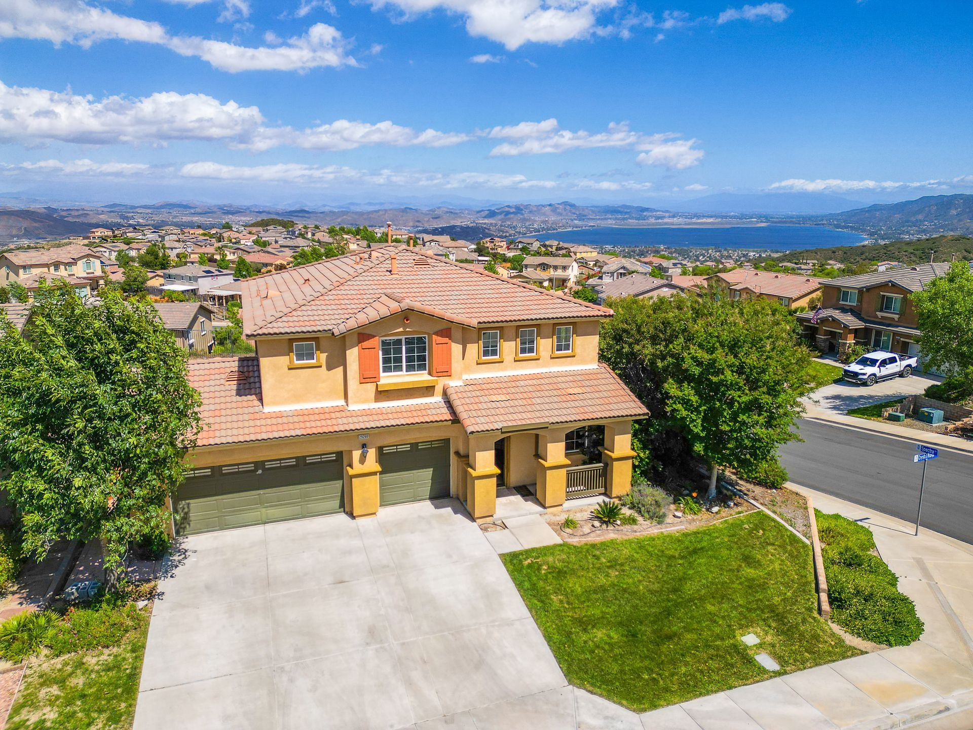 Two-story house with tan stucco, red tile roof, overlooking Lake Elsinore.