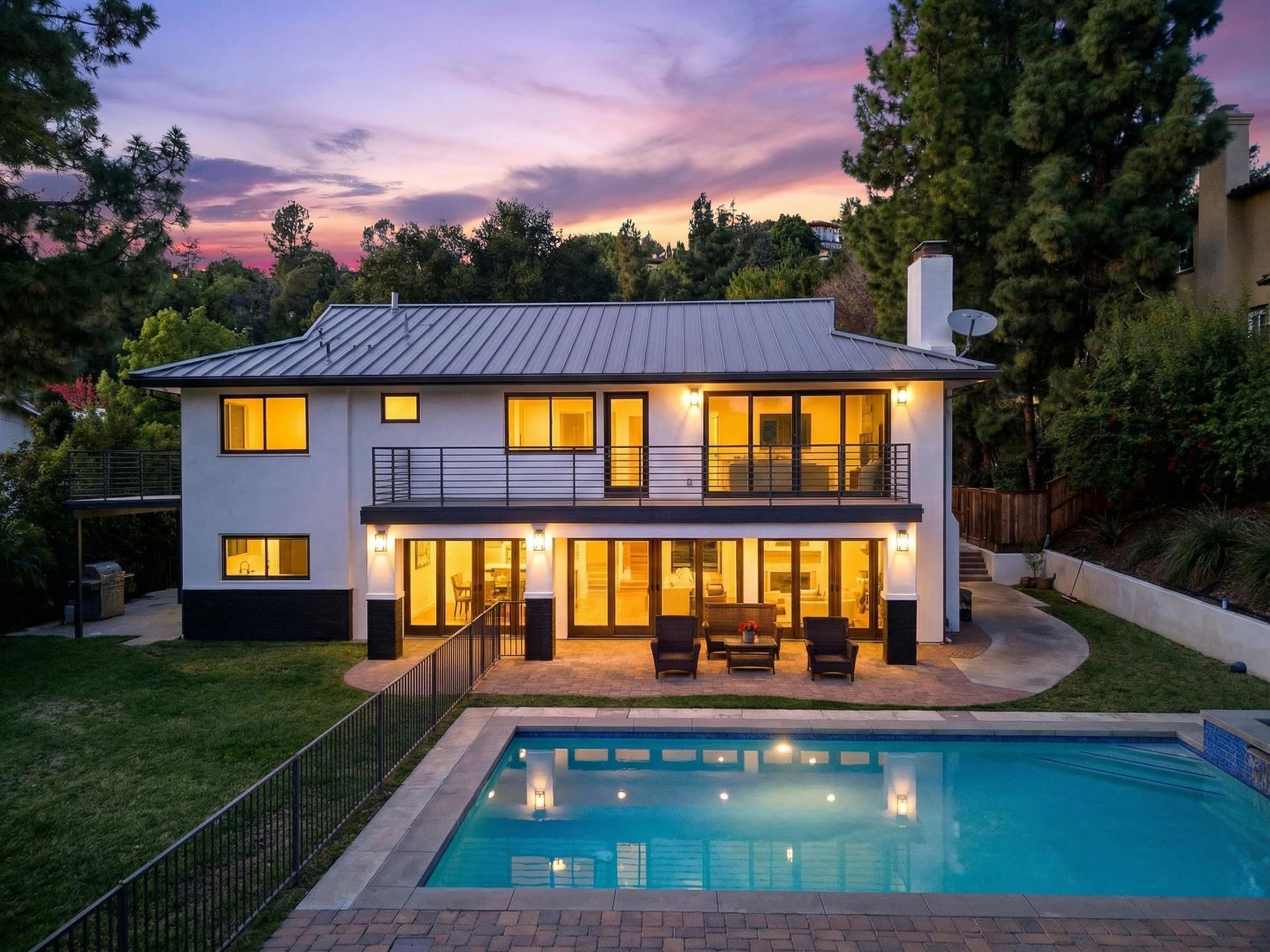Twilight view of backyard with pool