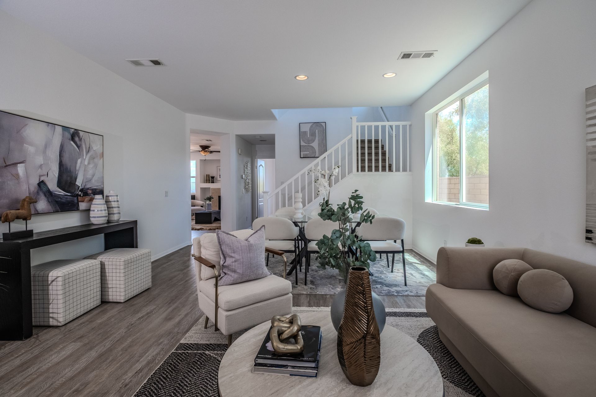 Living room with white walls, light gray flooring, and neutral furniture.