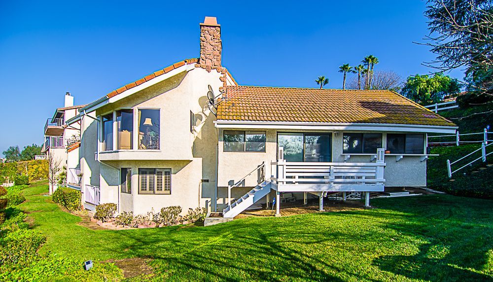 A large white house with a large lawn in front of it.