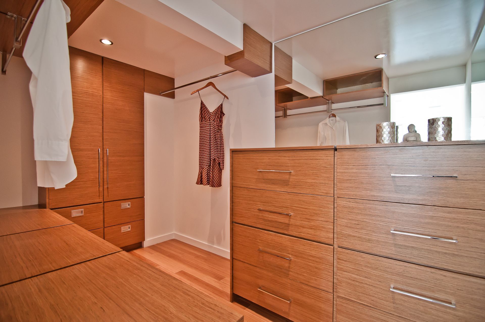 A walk in closet with wooden cabinets and drawers