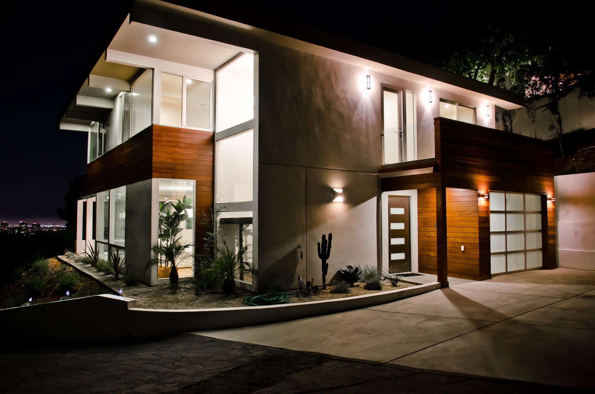 A large house with a lot of windows is lit up at night