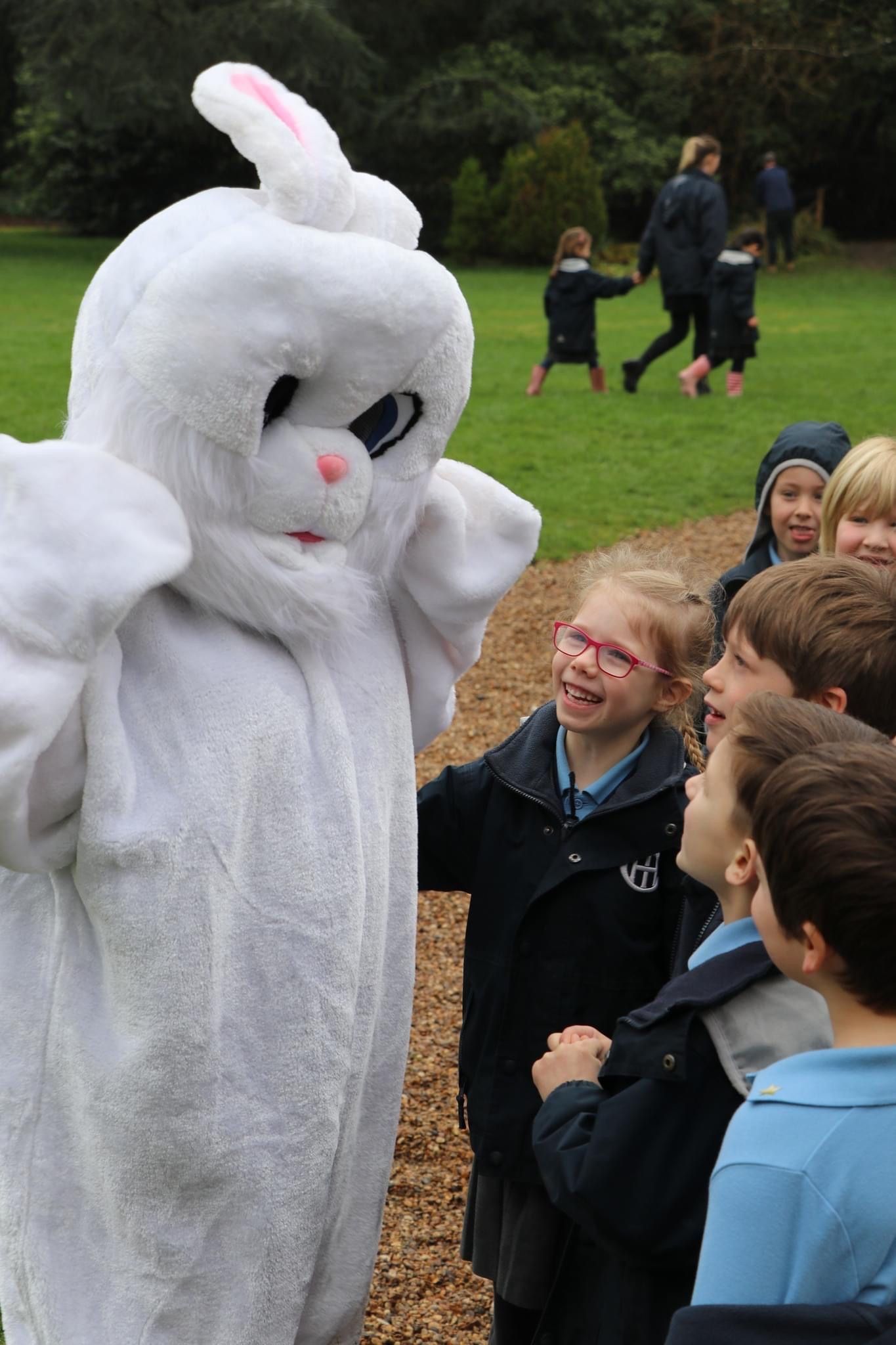 Easter Bunny interacting with a group of excited children outdoors.